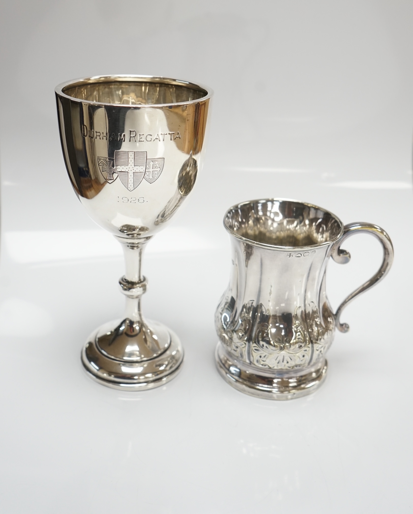 A George V silver goblet, Harrison & Sons, Birmingham, 1925, 15.3cm and a silver plated christening mug. Condition - fair